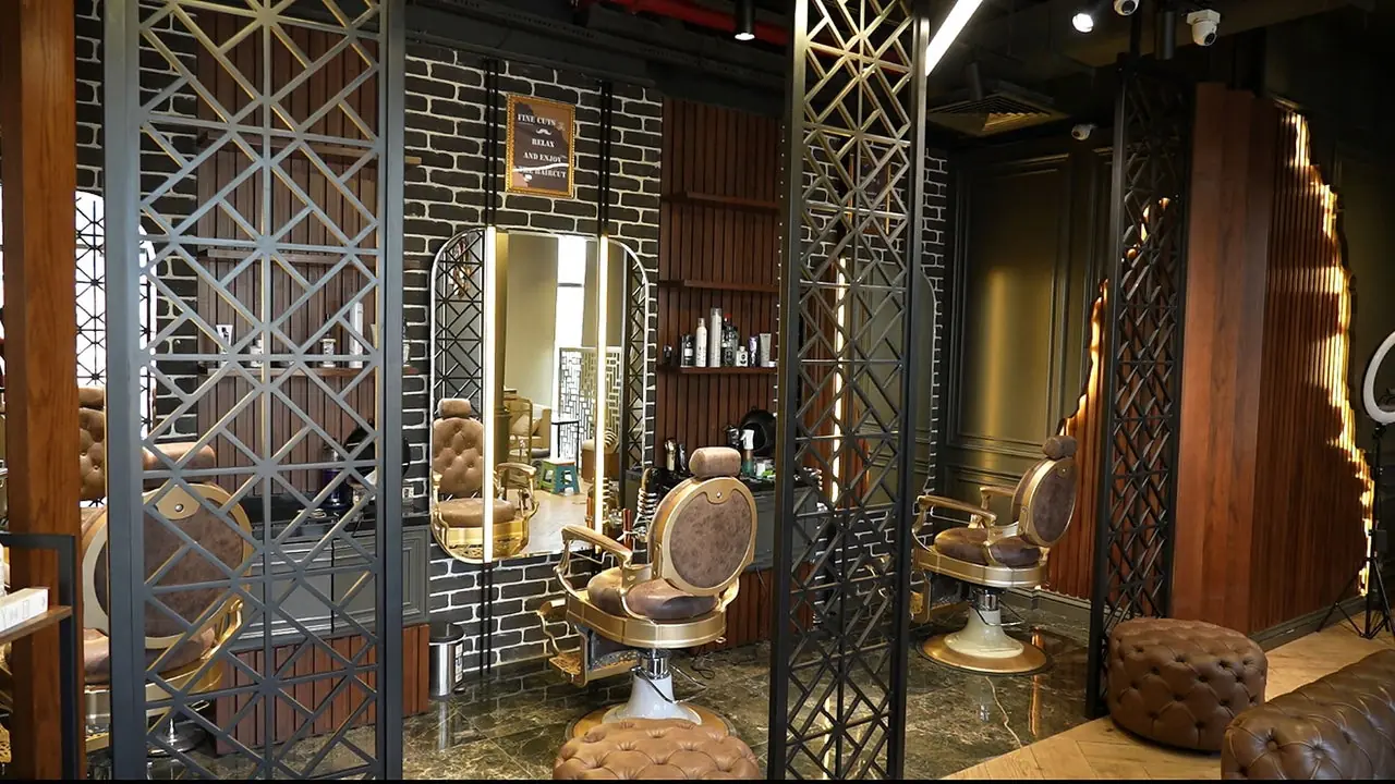 Gold barber chairs and lattice mirrors inside Fine Cuts Gents Salon